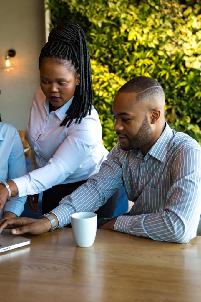 people pointing at computer screen in office